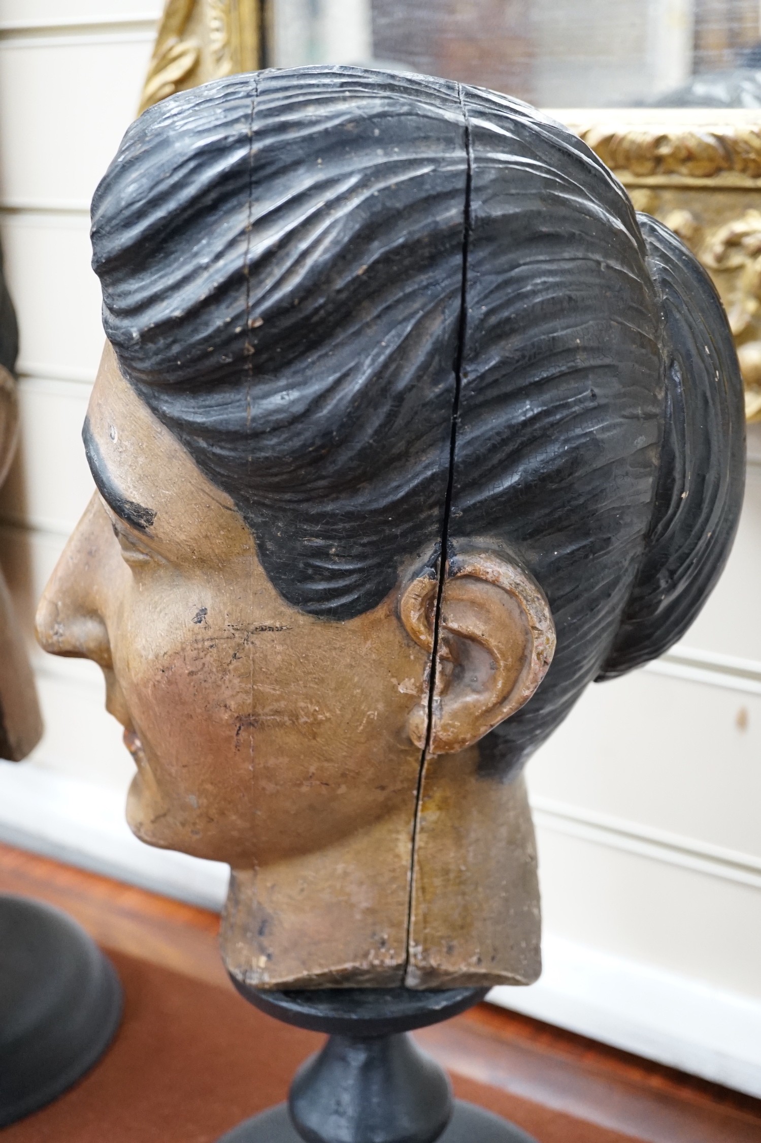 Two 20th century Italian carved and painted wooden heads on stands, 47cm